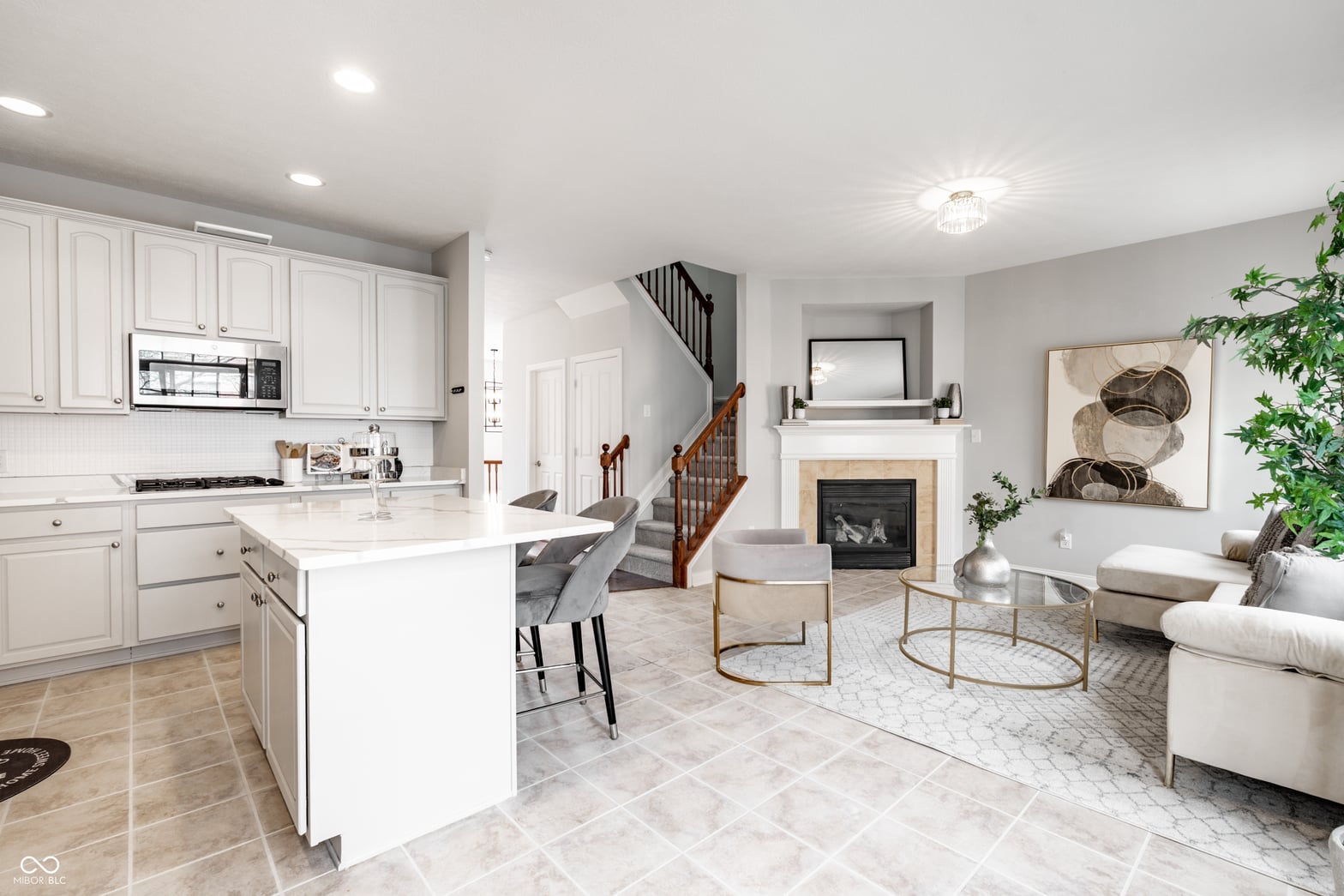 Modern white kitchen with island opens to living space.