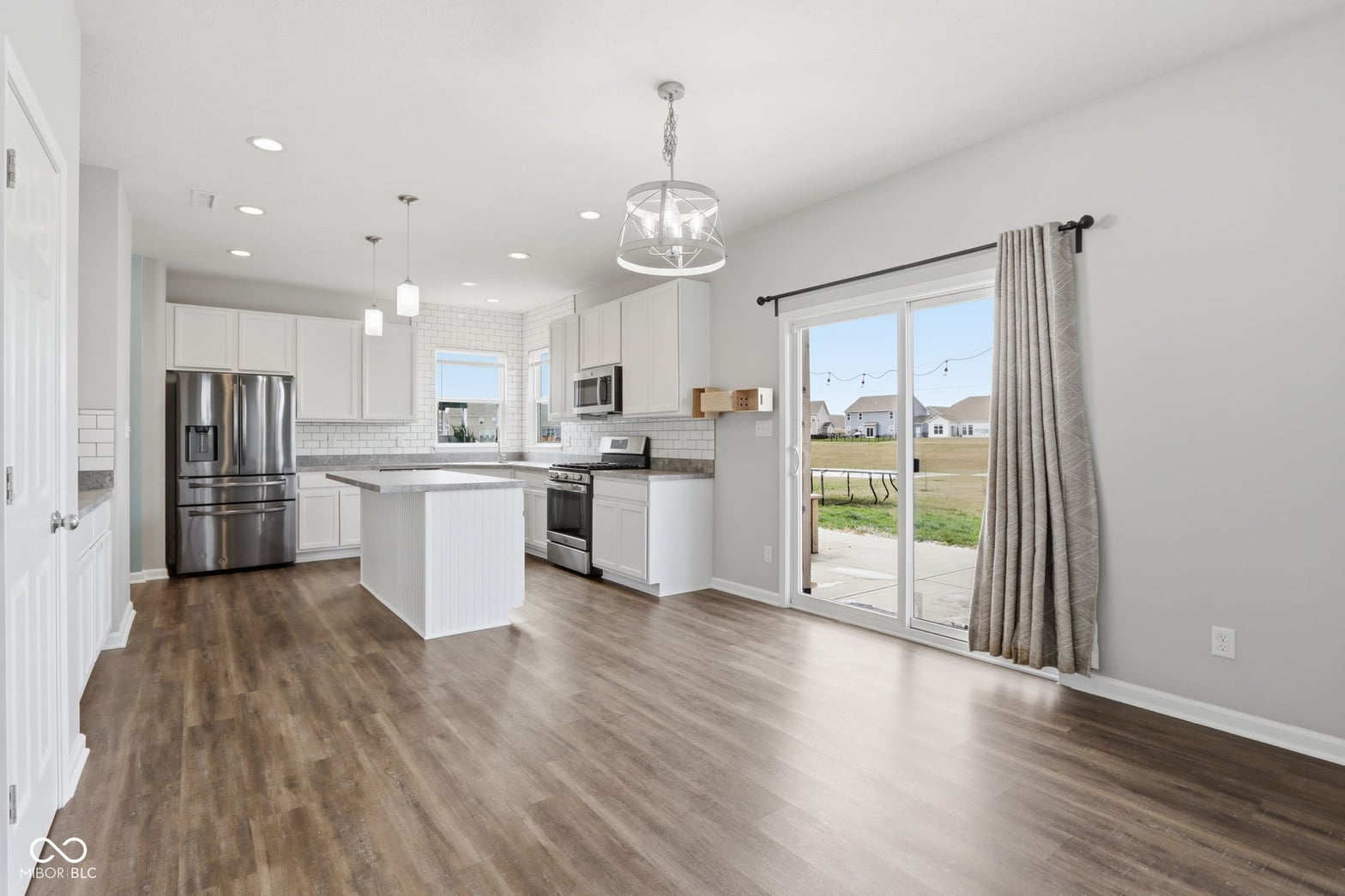 Bright modern kitchen with island and outdoor views.