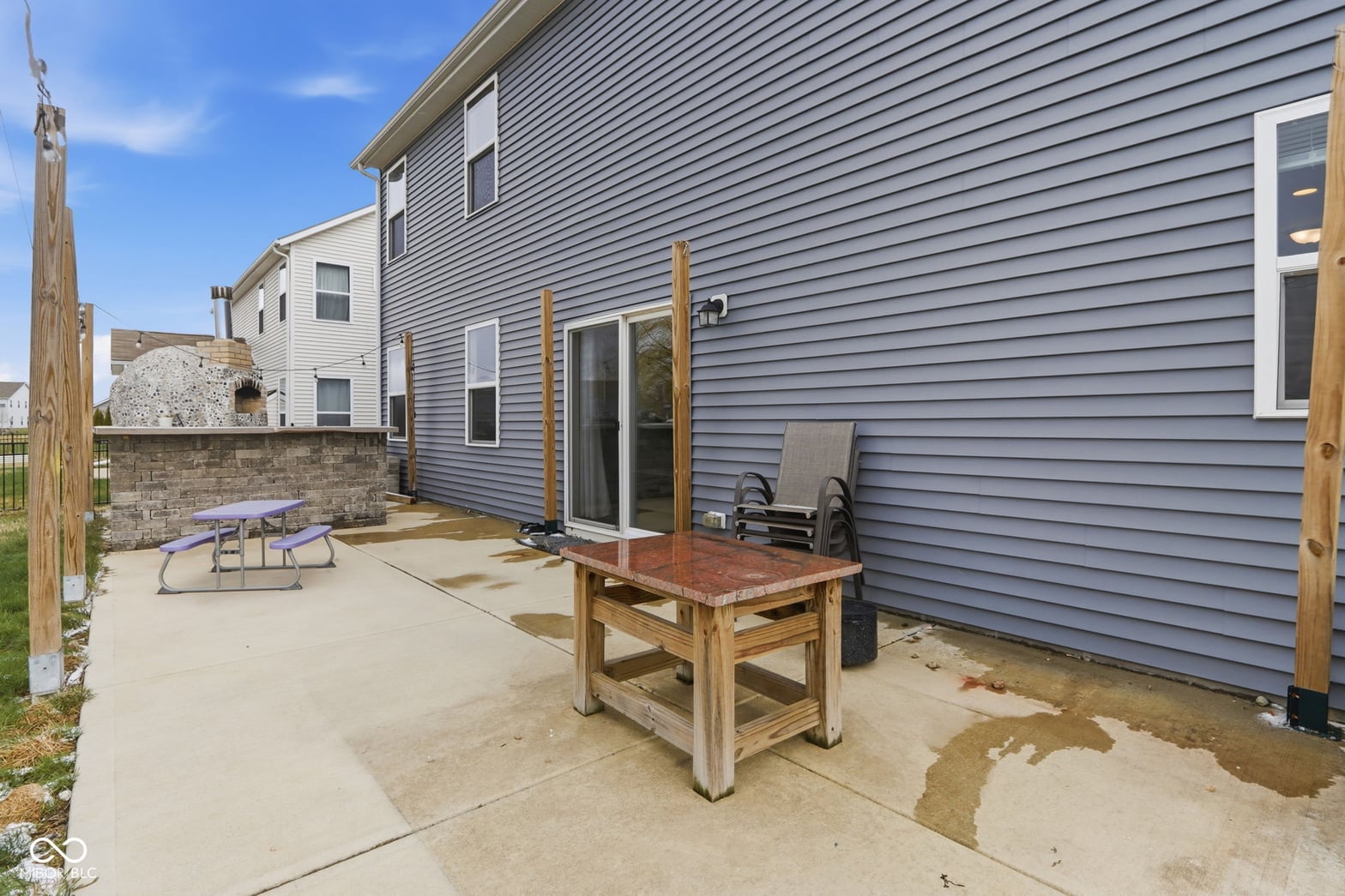 Modern backyard patio with pergola and retaining wall.