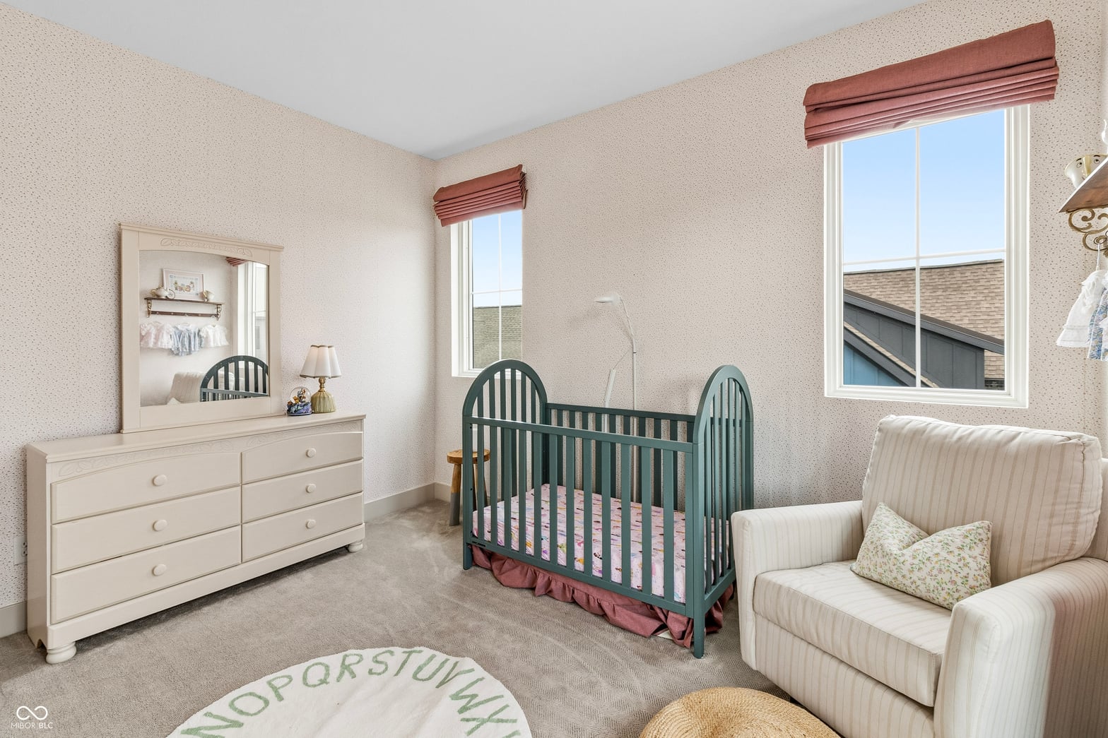 Bright nursery with elegant furniture and ample windows.