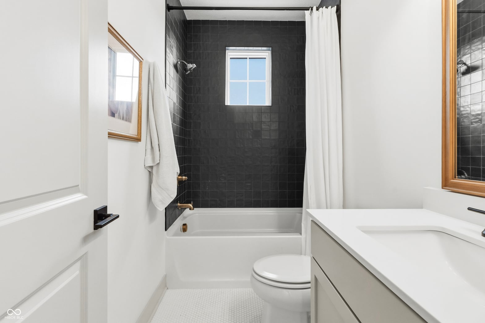 Bright, modern spa bathroom with black and white tile.