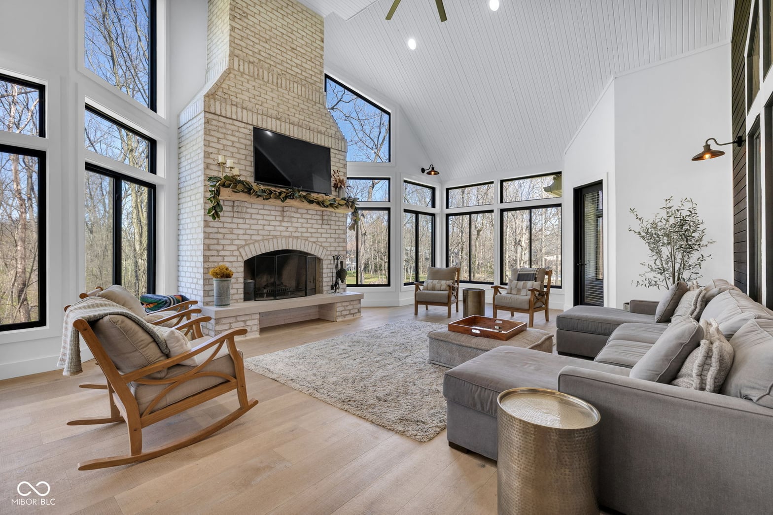 Spacious modern living room with soaring vaulted ceilings and fireplace.