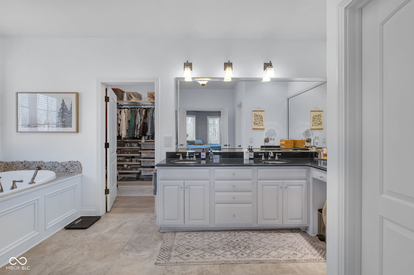Luxurious primary bath with double vanity and walk-in closet.