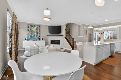 Living room at 11571 Huffington Street, Carmel, IN — Bright open-concept space with fireplace and modern kitchen.