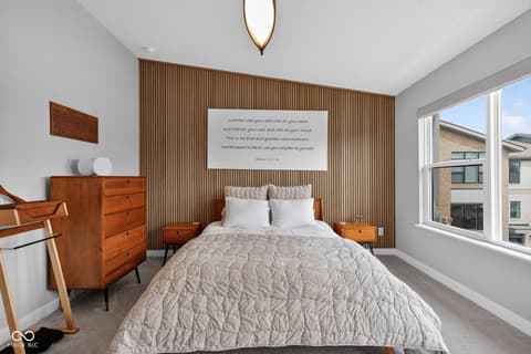 Primary bedroom at 11571 Huffington Street, Carmel, IN — Stunning mid-century primary bedroom with wood accent wall.