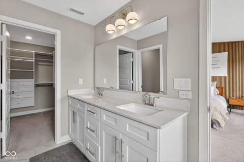 Primary bathroom at 11571 Huffington Street, Carmel, IN — Luxurious primary bath with dual vanity and walk-in closet.