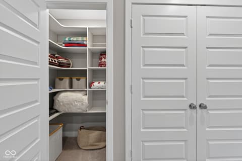 Bedroom at 11571 Huffington Street, Carmel, IN — Spacious walk-in closet with custom built-in shelving.