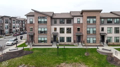 Front exterior at 11571 Huffington Street, Carmel, IN — New construction contemporary townhomes with brick facades.