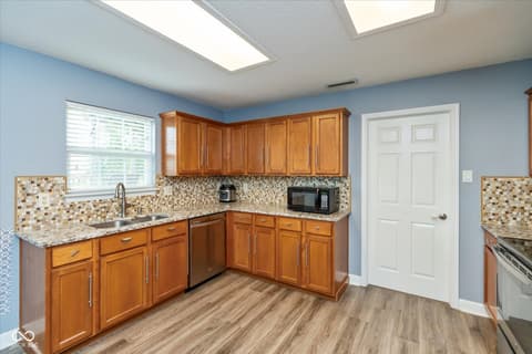 Kitchen at 10270 Apple Blossom Circle, Fishers, IN — Bright kitchen with wood cabinets and granite counters.