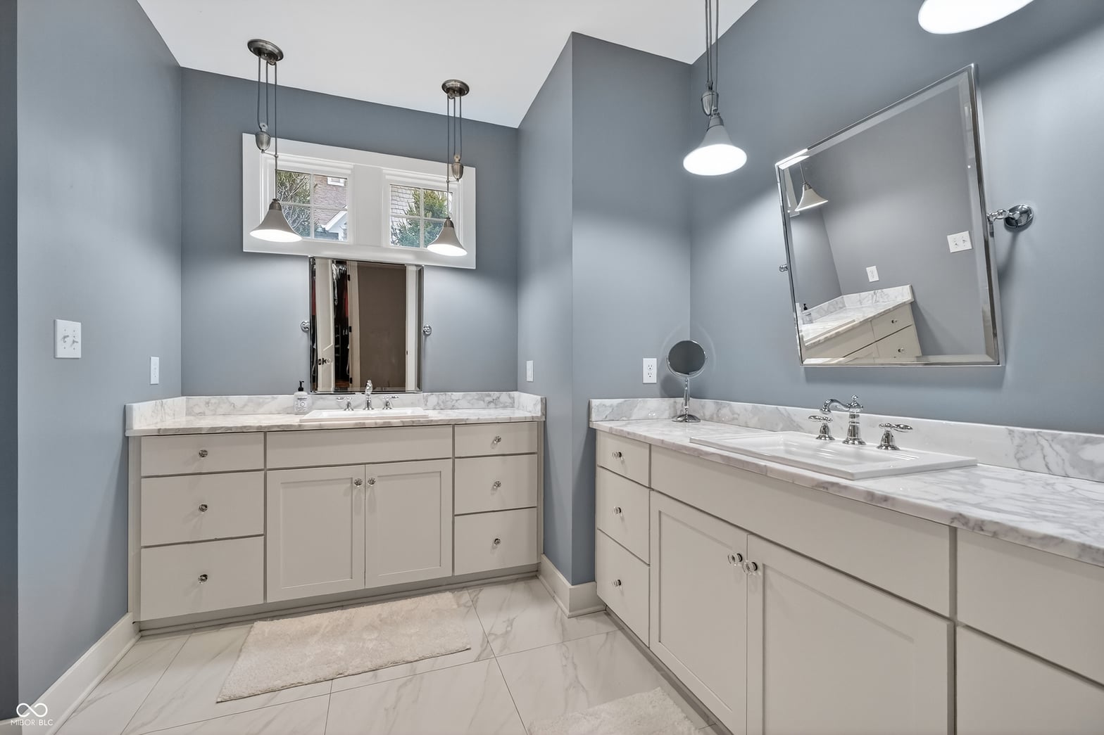 Luxurious primary bath with dual marble vanities and spa-like tub.