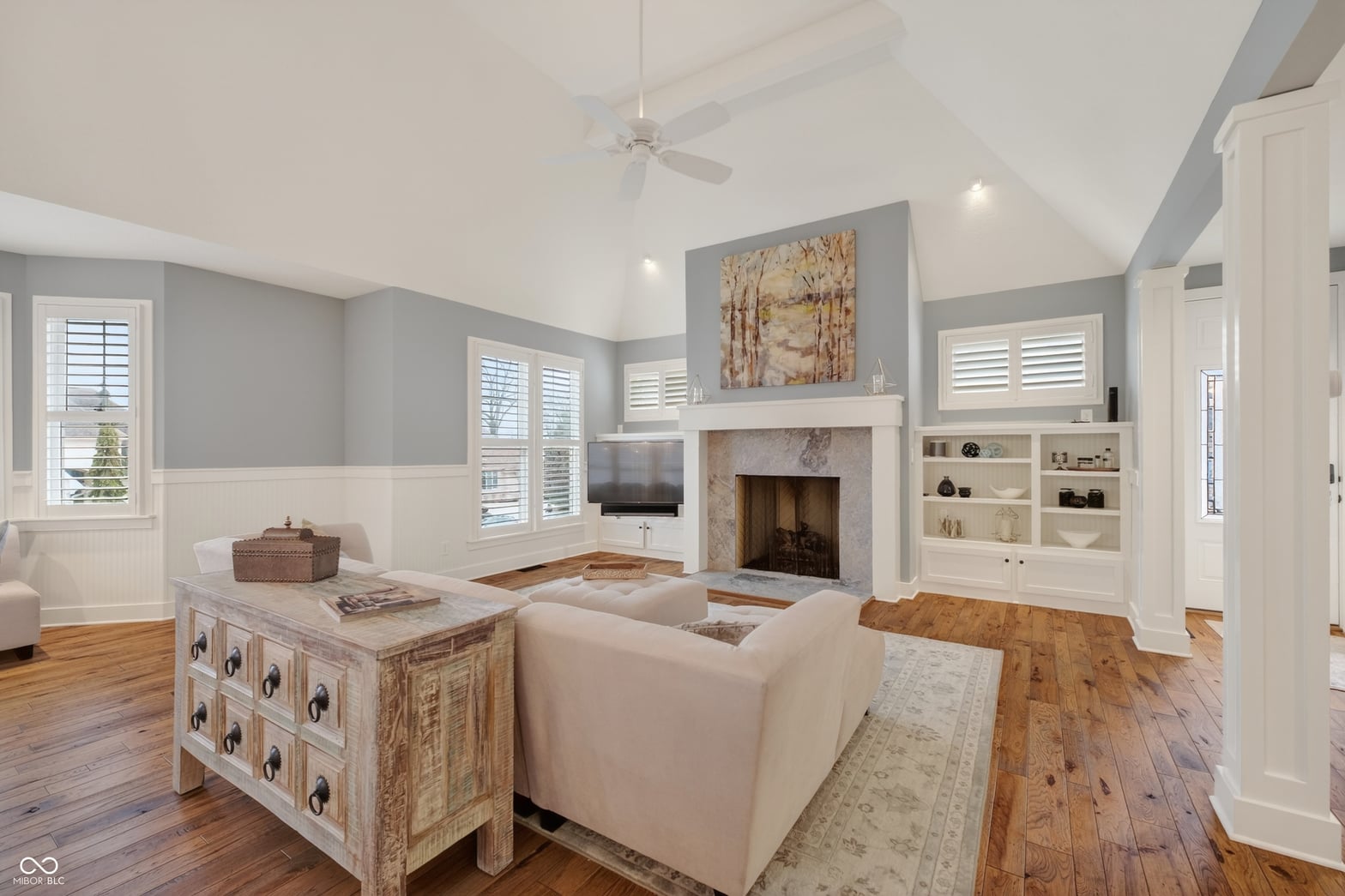 Bright family room with fireplace and built-in shelving.