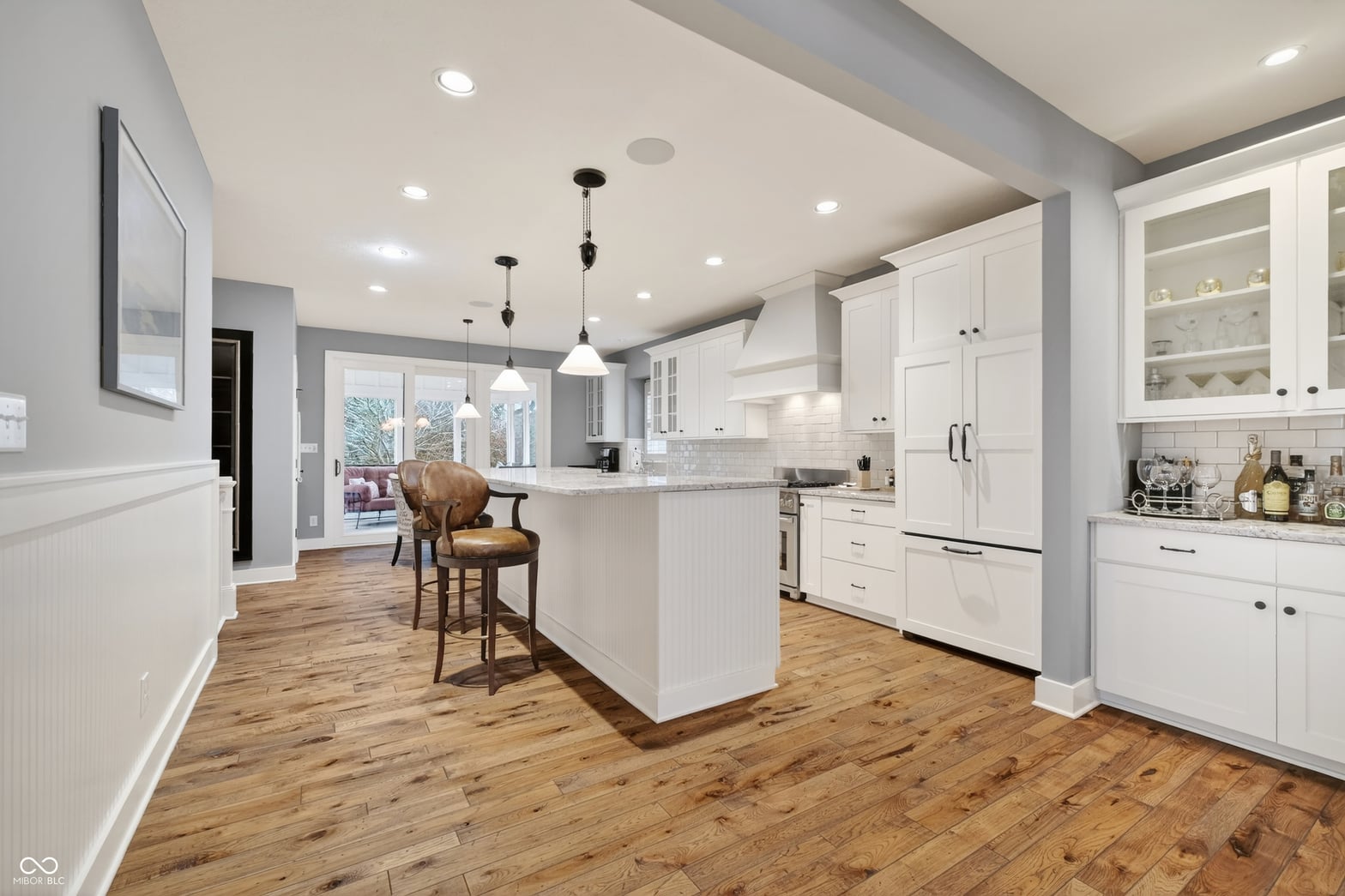 Bright, spacious kitchen with white cabinets and island seating.