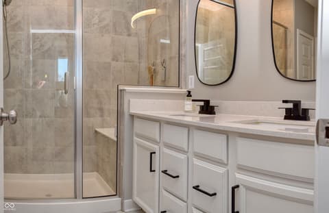 Primary bathroom at 6583 Apperson Drive, Noblesville, IN — Luxurious primary bath with dual vanity and marble tile.