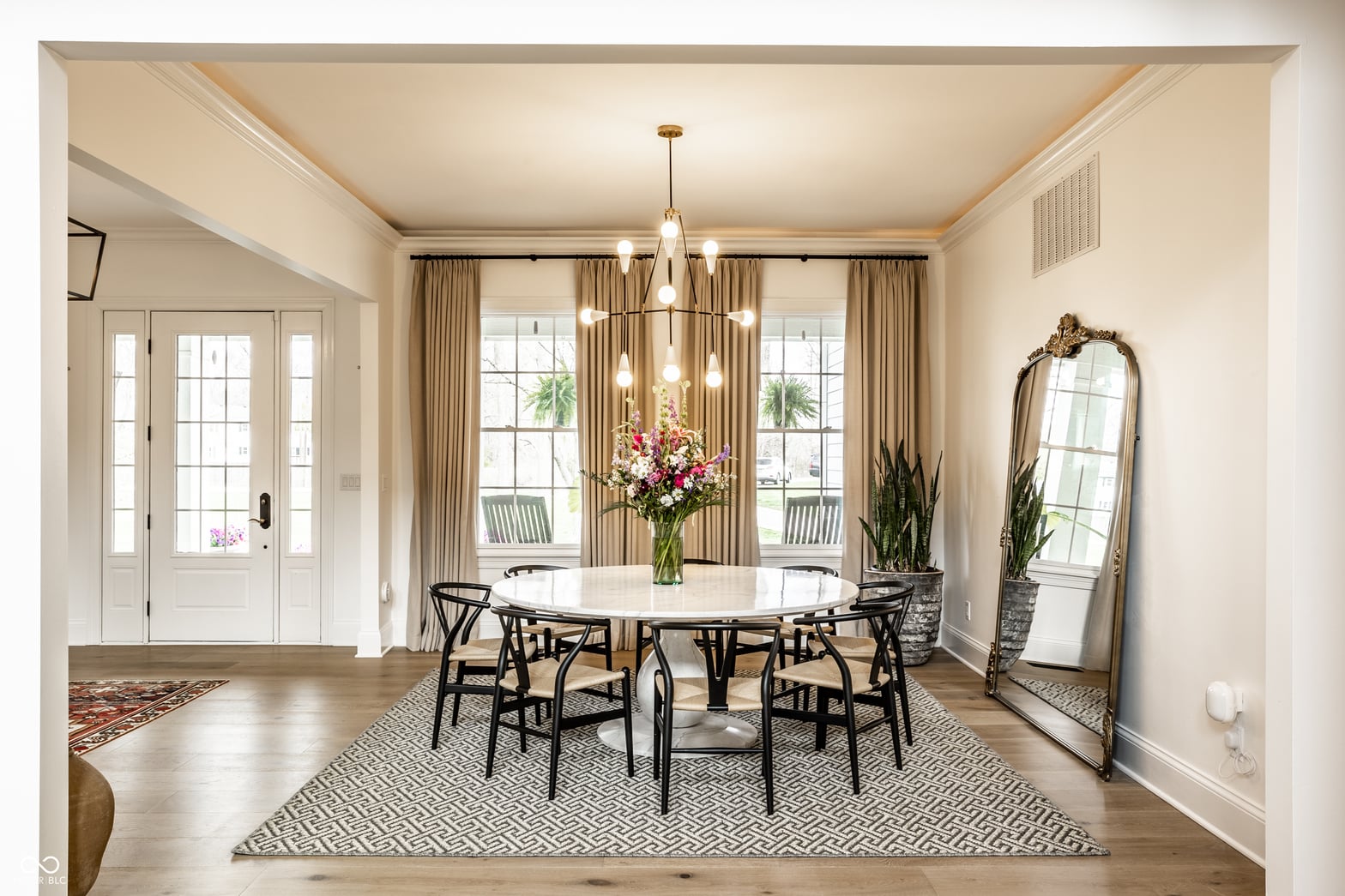 Elegant dining room with marble table and abundant natural light.