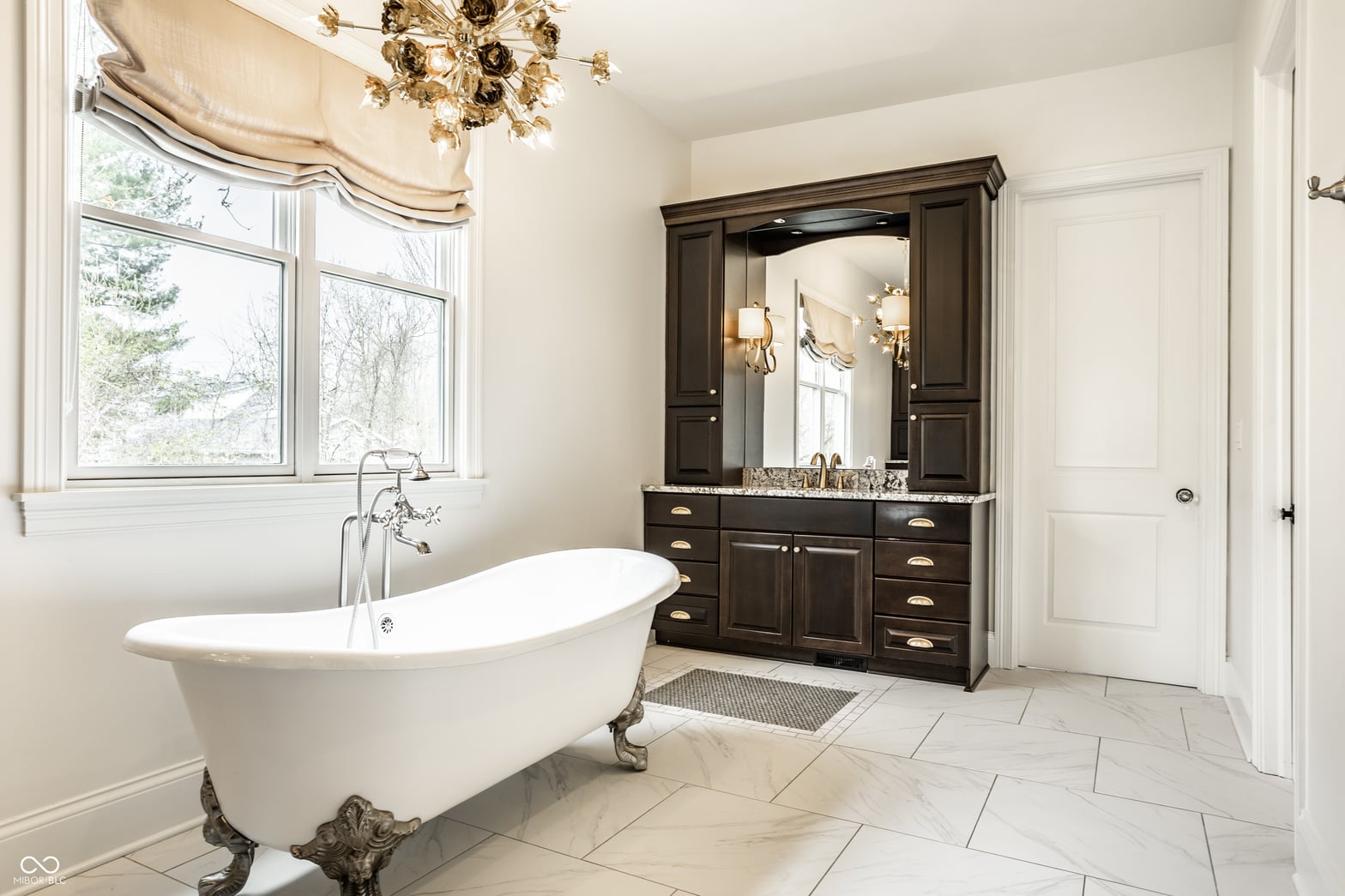 Luxurious primary bath with freestanding soaking tub and marble finishes.