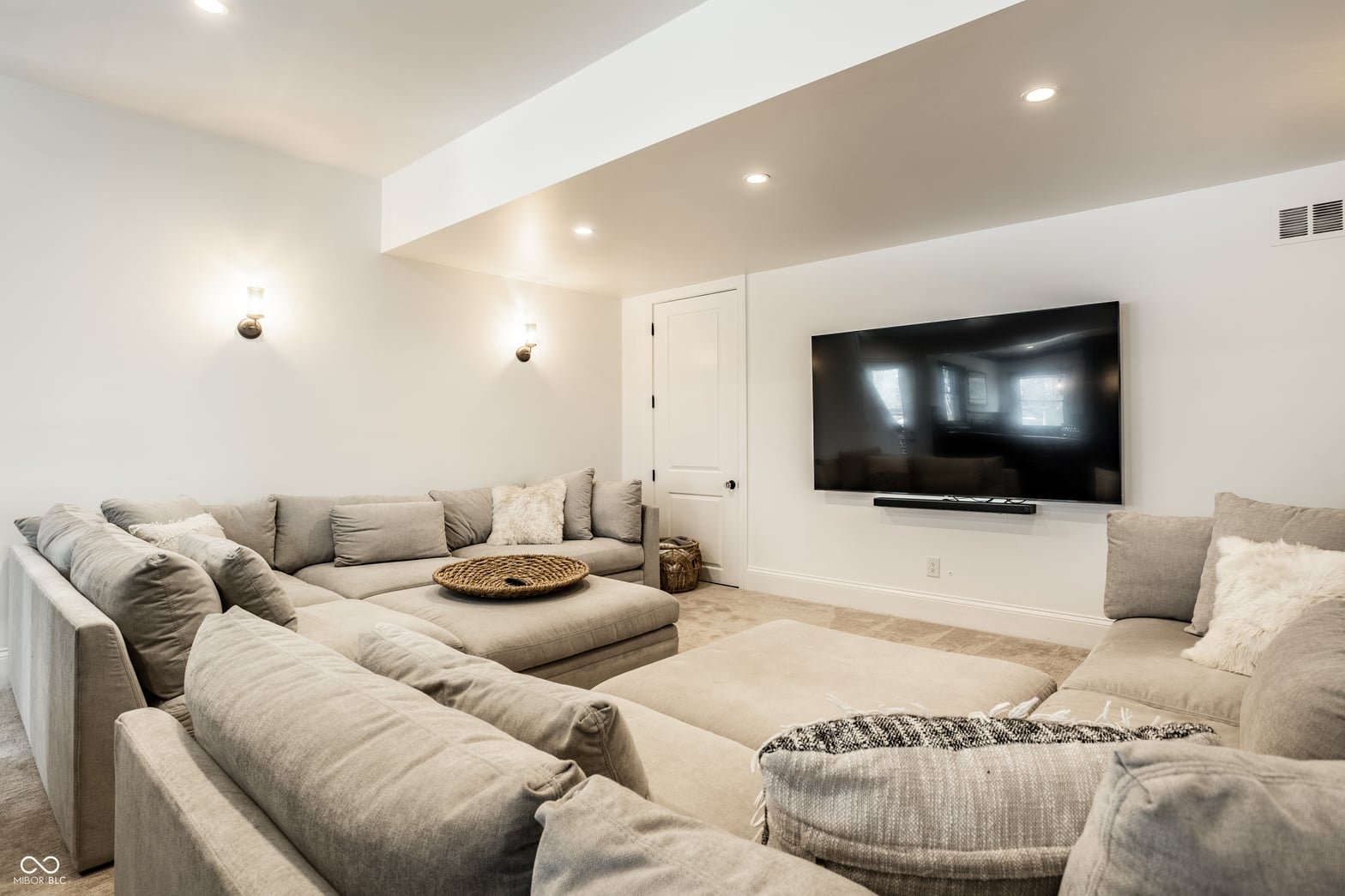 Modern media room with curved ceiling and premium seating.