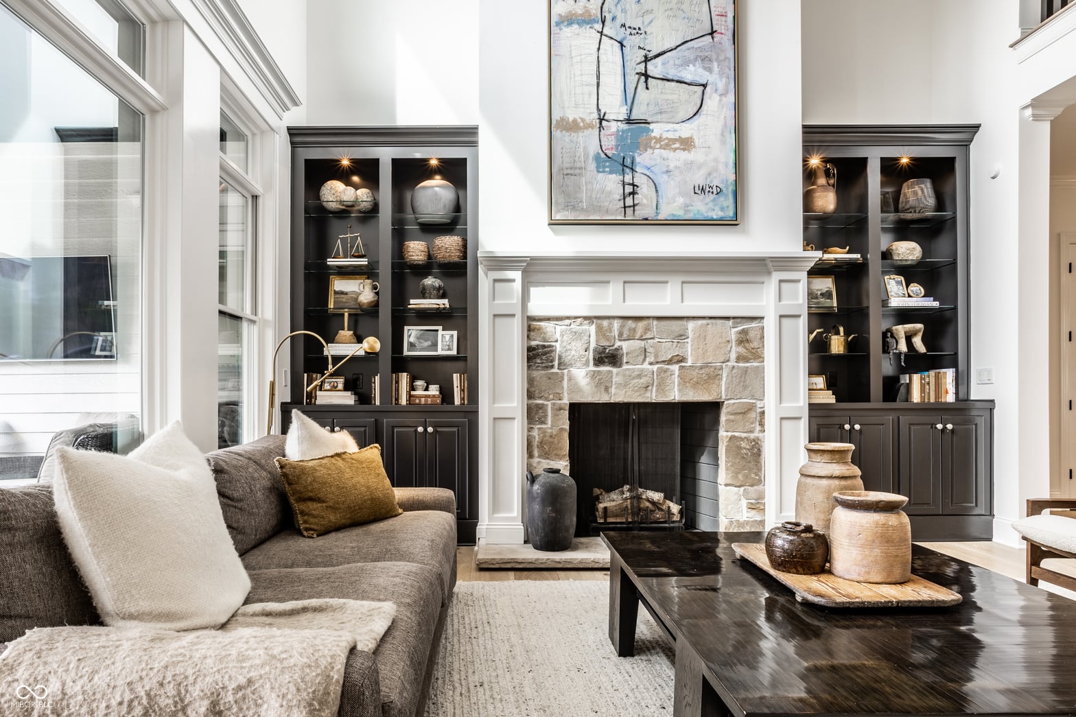 Elegant living room with stone fireplace and built-in cabinetry.