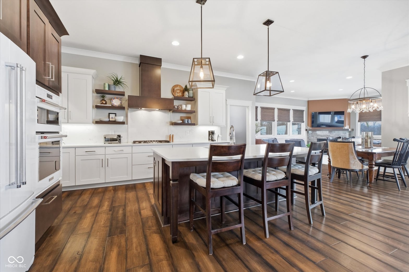 Modern kitchen with hardwood floors and open living space.