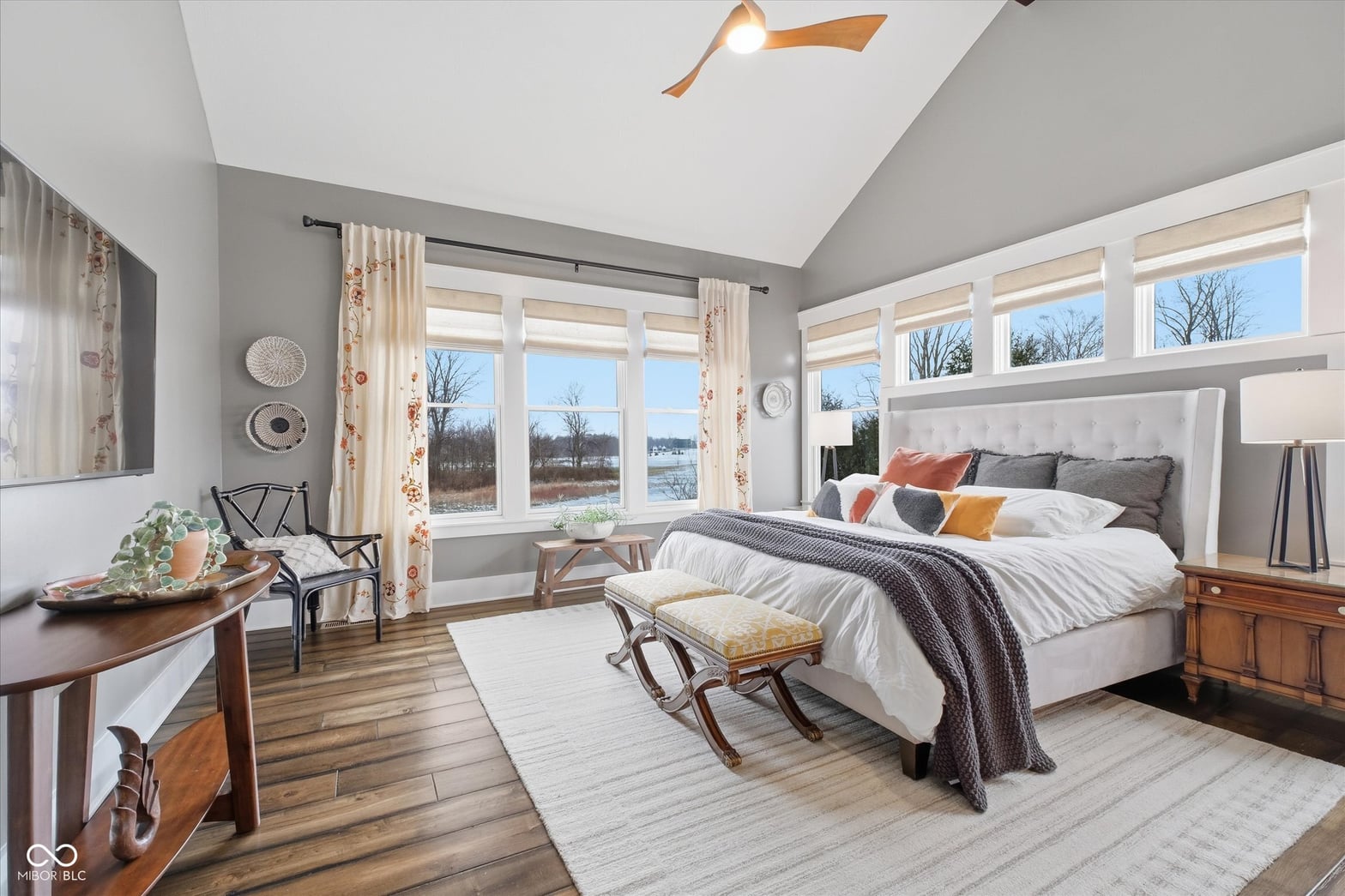 Bright primary suite with water views and vaulted ceilings.