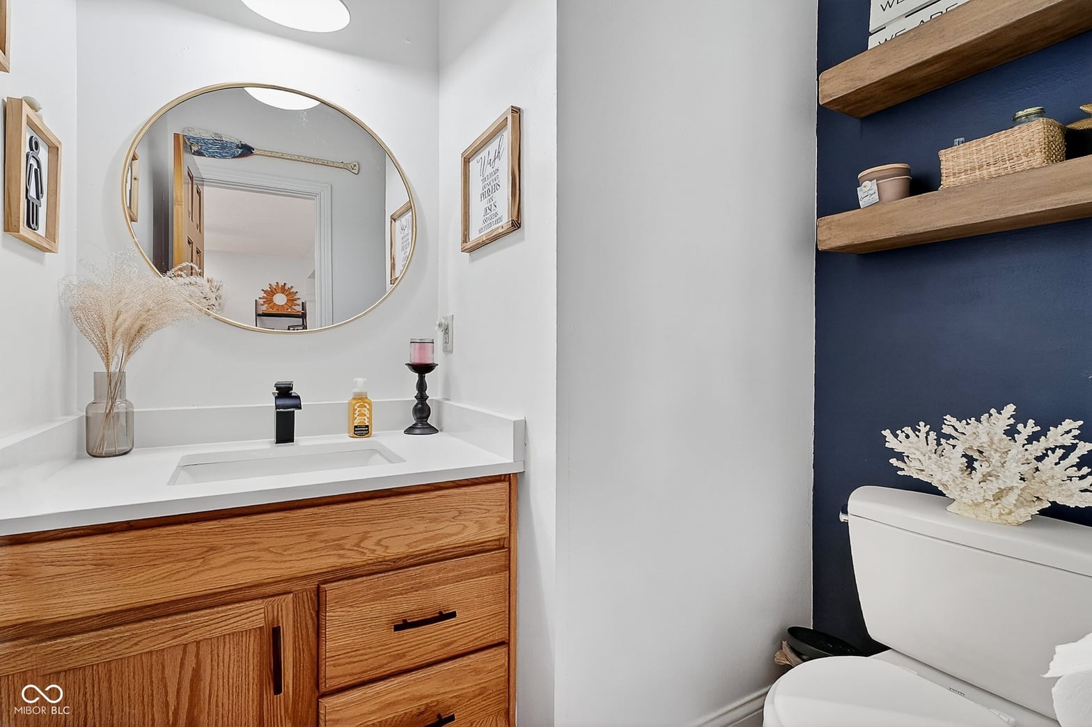 Stylish primary bath with navy accent wall and floating shelves.
