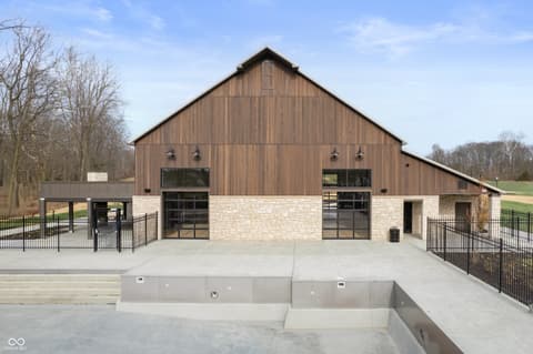 Front exterior at 11388 Selsey Road, Fishers, IN — Stunning modern barn conversion with stone and metal facade.