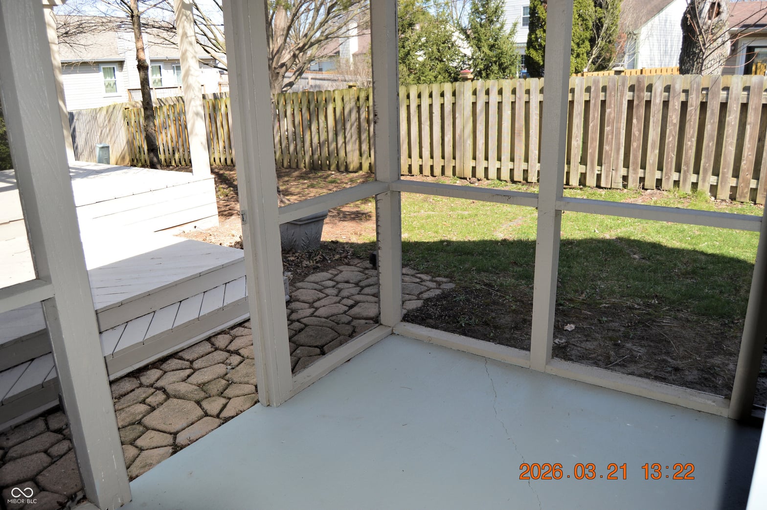 Spacious screened porch with fenced yard and mature landscaping.