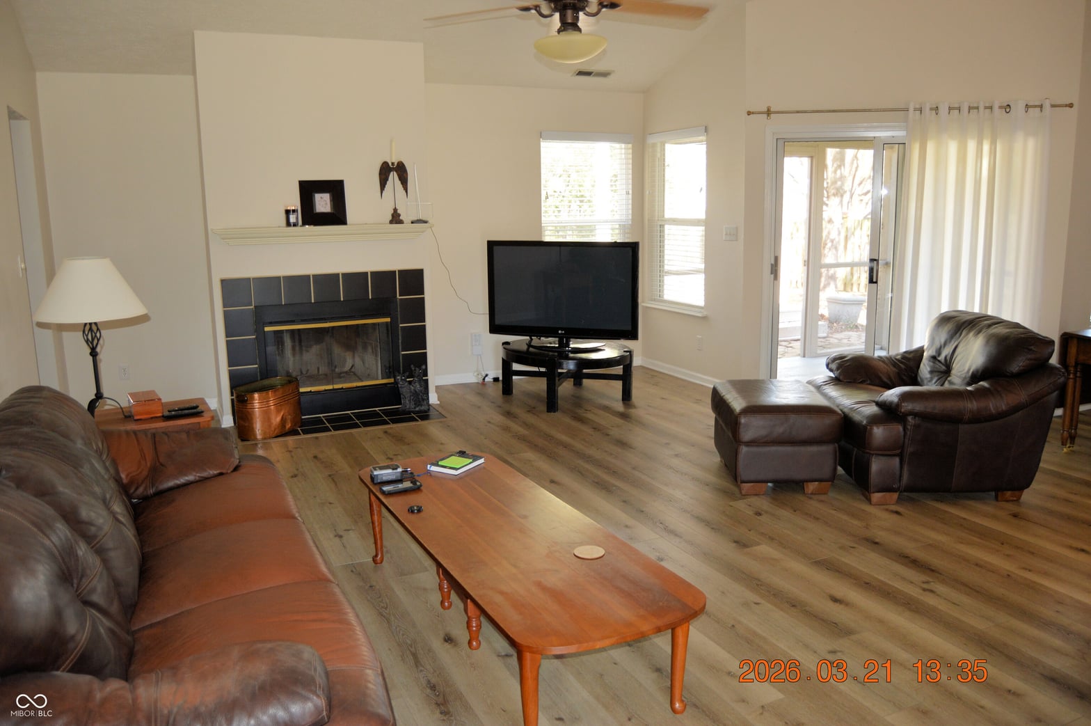 Spacious living room with fireplace and patio access.
