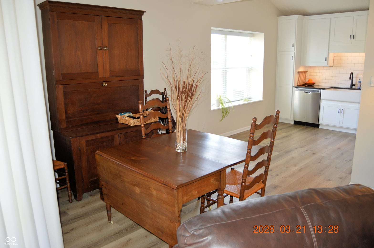 Spacious dining room with hardwood floors and open kitchen.