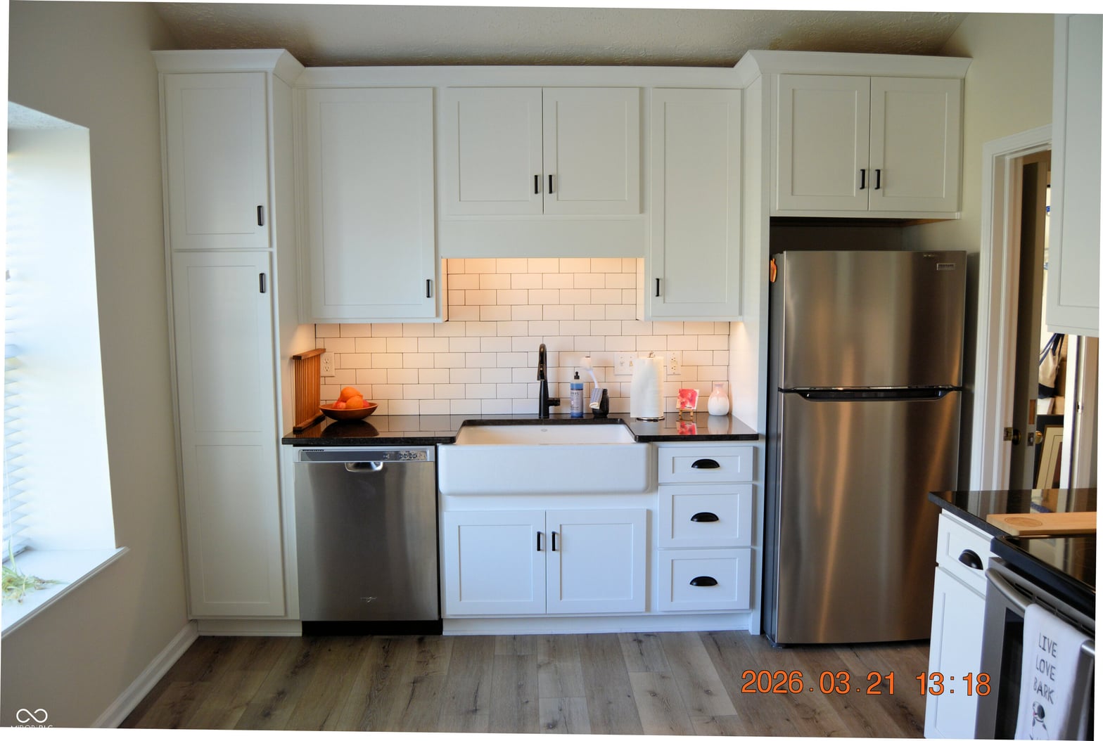 Renovated kitchen with white cabinets and farmhouse sink.