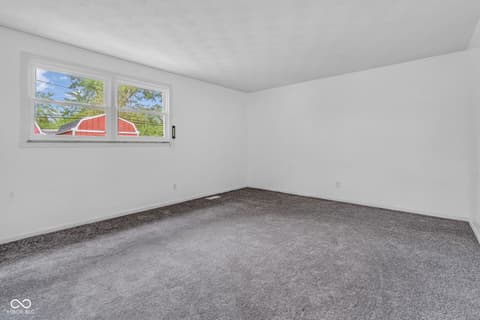 Bedroom at 18 Wilson Drive, Carmel, IN — Bright bedroom with large windows and new carpet.