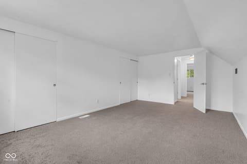 Bedroom at 18 Wilson Drive, Carmel, IN — Spacious bedroom with vaulted ceilings and abundant storage.
