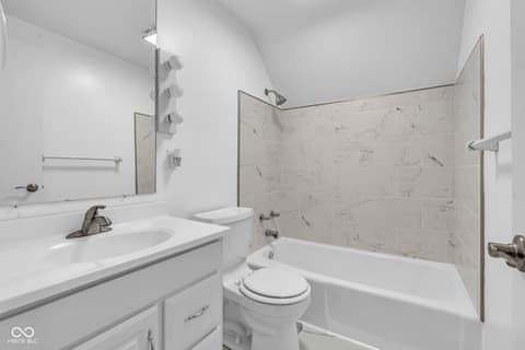 Primary bathroom at 18 Wilson Drive, Carmel, IN — Bright modern bathroom with marble shower surround.