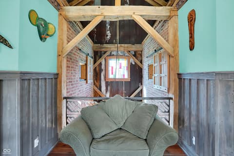 Bedroom at 25811 State Road 19, Arcadia, IN — Charming loft bedroom with exposed beams and skylights.