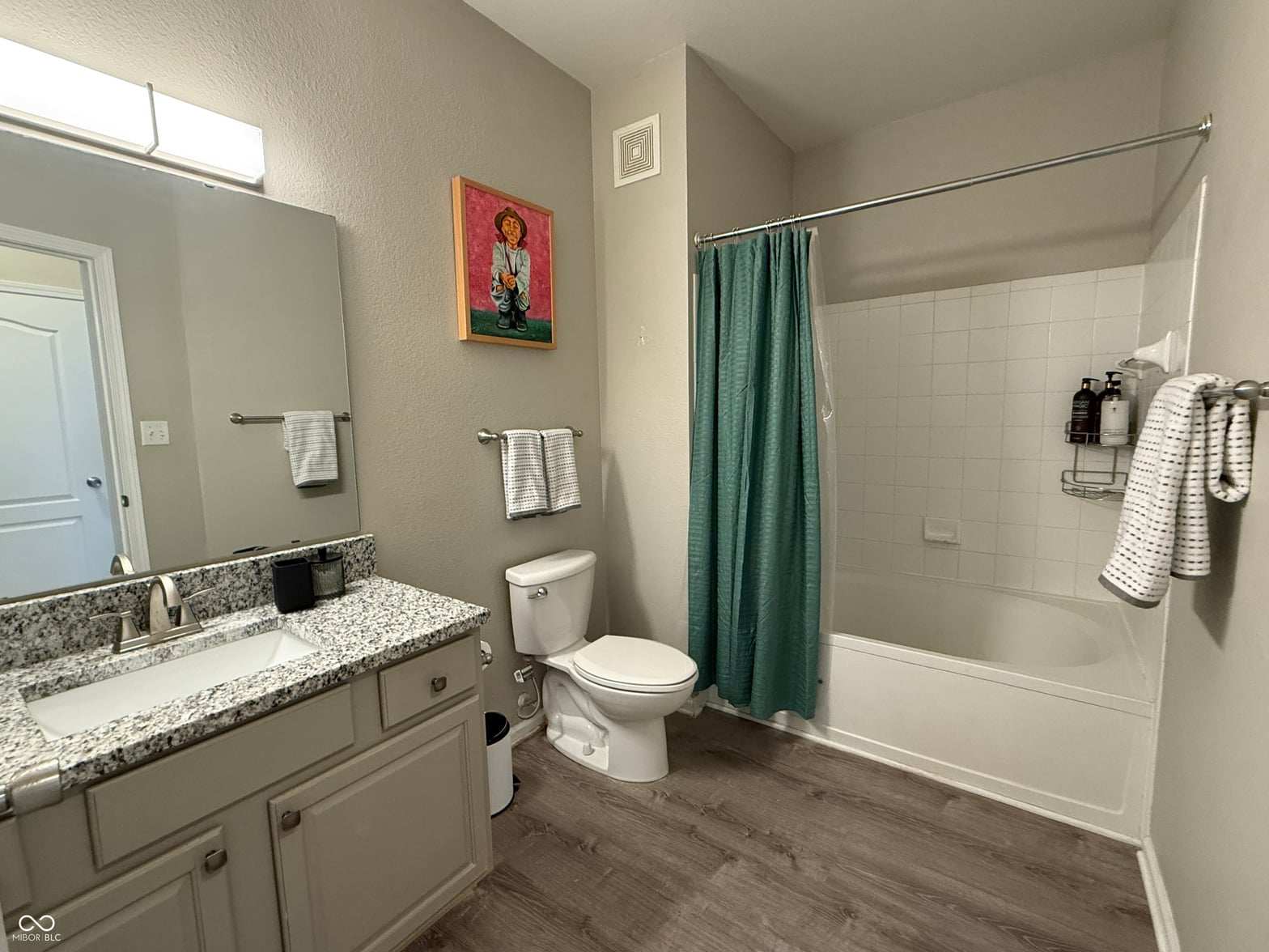 Spacious primary bath with granite double vanity and tile shower.