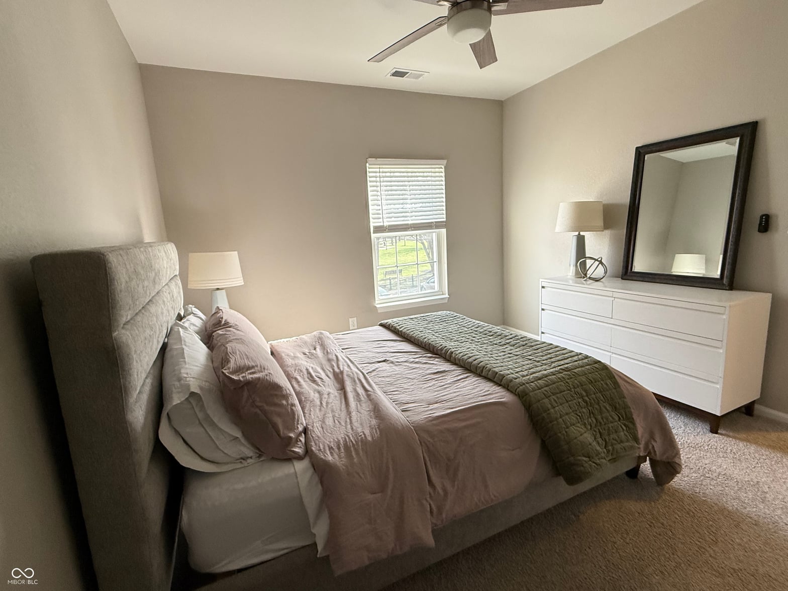 Bright primary bedroom with updated furnishings and natural light.