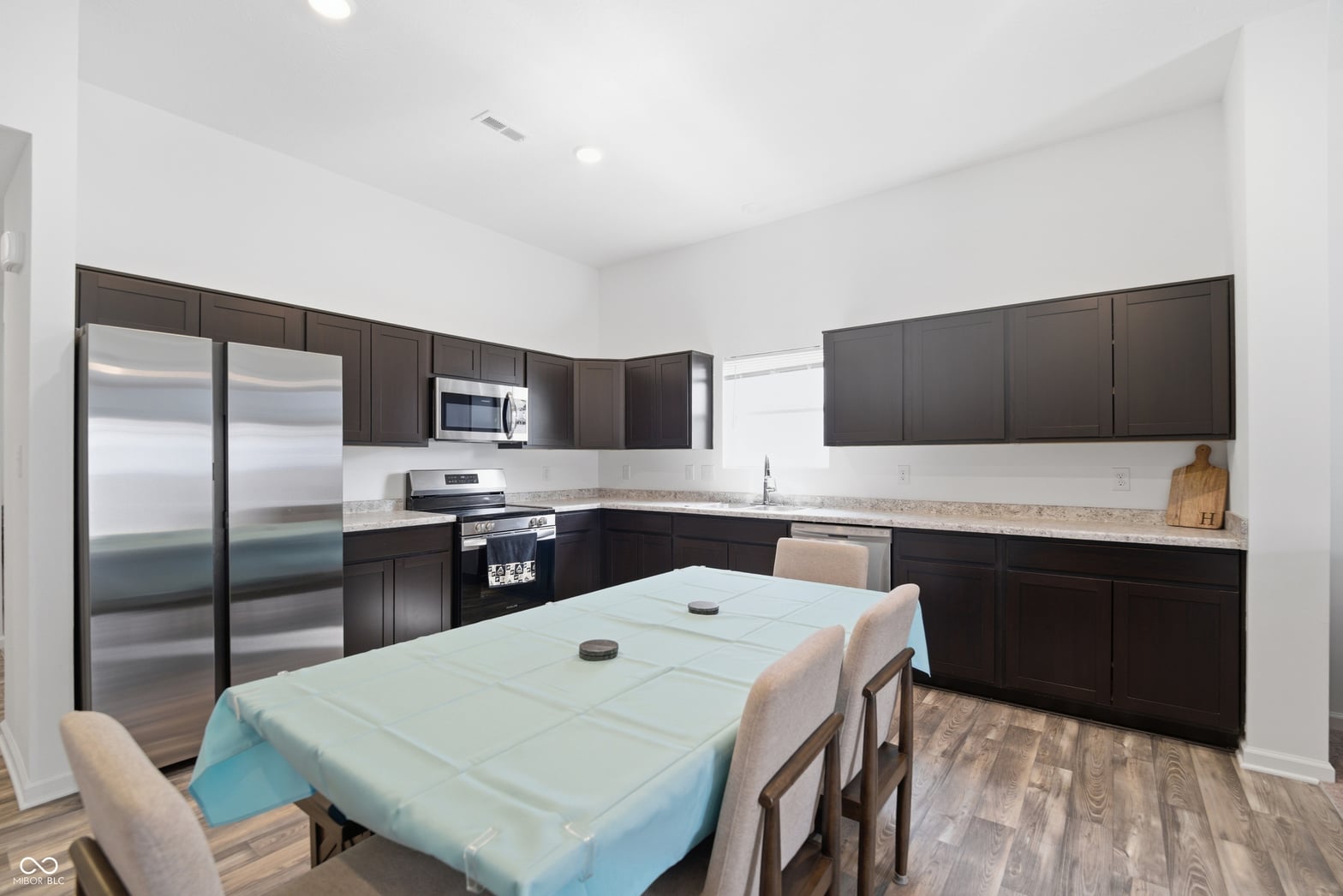 Modern kitchen with dark cabinets and granite counters.