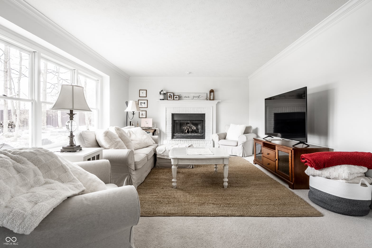 Bright, airy living room with fireplace and abundant natural light.
