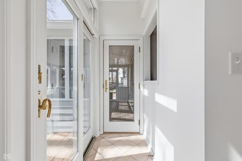 Hallway at 15 Wildwood Drive, Carmel, IN — Bright hallway with geometric tile and glass doors to deck.