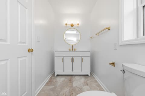 Primary bathroom at 15 Wildwood Drive, Carmel, IN — Spa-like primary bath with marble floors and gold fixtures.