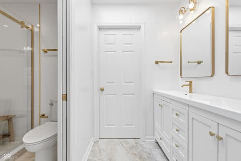 Primary bathroom at 15 Wildwood Drive, Carmel, IN — Luxe primary bath with dual vanity and gold accents.