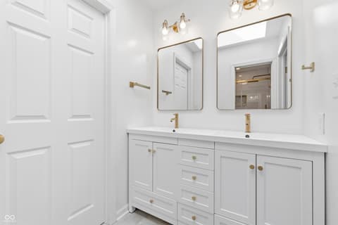 Primary bathroom at 15 Wildwood Drive, Carmel, IN — Luxurious dual vanity bathroom with modern brass accents.