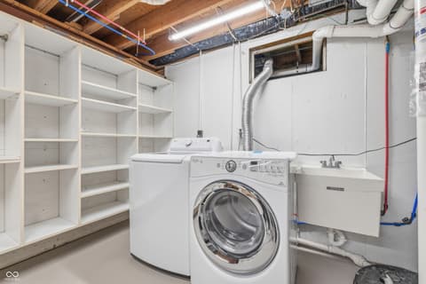 Laundry room at 15 Wildwood Drive, Carmel, IN — Modern laundry room with abundant built-in storage shelving.
