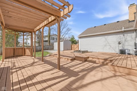 Outdoor living area at 15 Wildwood Drive, Carmel, IN — Expansive composite deck with elegant pergola and seating.