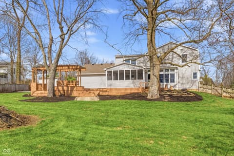 Backyard at 15 Wildwood Drive, Carmel, IN — Spacious backyard with mature trees and updated deck.