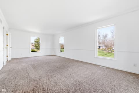 Living room at 15 Wildwood Drive, Carmel, IN — Bright, spacious living room with abundant natural light.