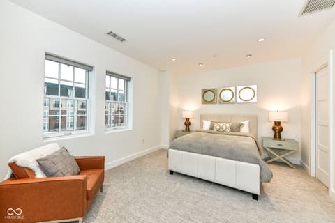 Primary bedroom at 30 W Main Street, Carmel, IN — Spacious primary suite with urban views and luxury finishes.