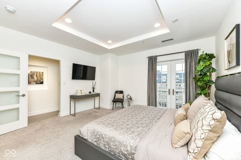 Primary bedroom at 30 W Main Street, Carmel, IN — Luxury primary suite with city views and modern amenities.