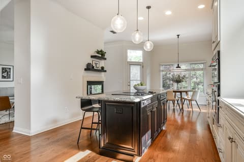 Kitchen at 12344 St Armands Circle, Carmel, IN — Stunning modern kitchen with large island and fireplace.