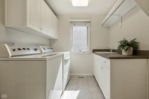 Laundry room at 12344 St Armands Circle, Carmel, IN — Bright, clean laundry room with modern white cabinetry.