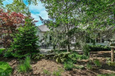 Backyard at 12344 St Armands Circle, Carmel, IN — Serene backyard with mature trees and landscaping.